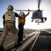 U.S. Sailor, assigned to the Iwo Jima Amphibious Ready Group, signals to an MH-60R Seahawk helicopter on the flight deck