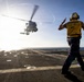 U.S. Sailor, assigned to the Iwo Jima Amphibious Ready Group, signals to an MH-60R Seahawk helicopter on the flight deck