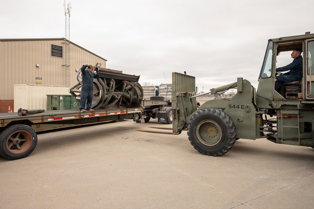 Airmen load an old and disabled snowblower