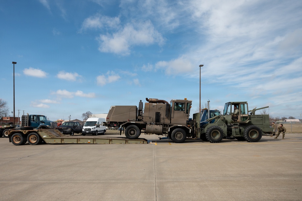 Airmen load an old and disabled snowblower