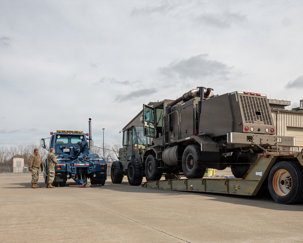 Airmen load an old and disabled snowblower