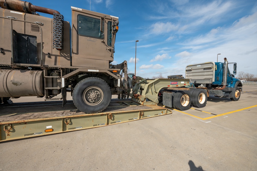 Airmen load an old and disabled snowblower