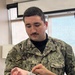 Corpsman Inspects Suture Work During Training