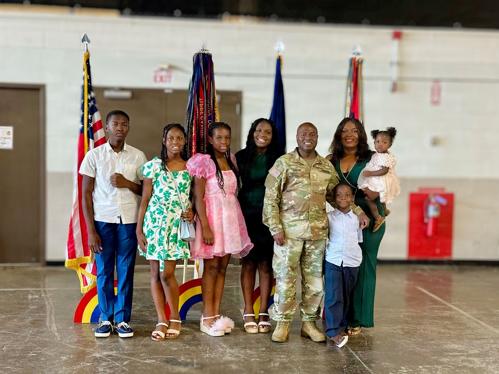Major Sorffly Dvius poses with his family following a ceremony.