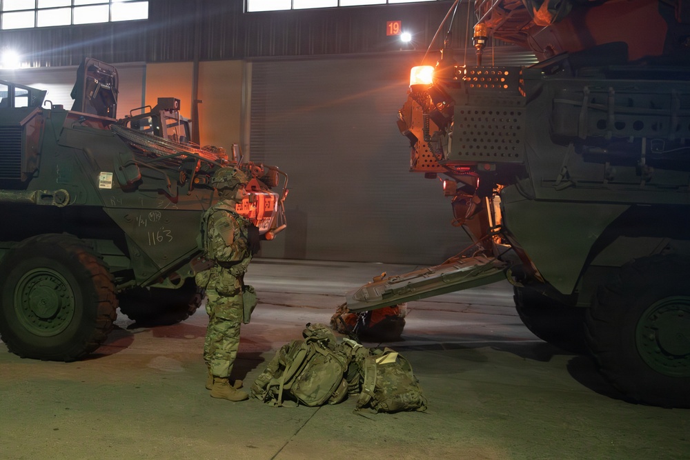 Soldier stands beside a M1126 Stryker