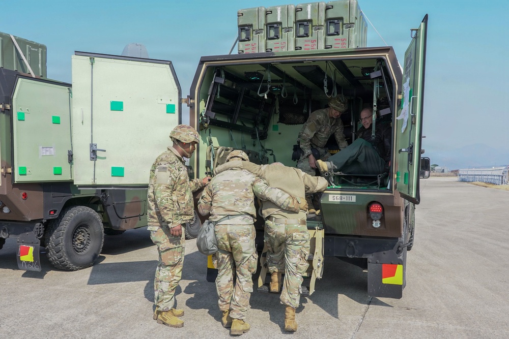 Medics load simulated patients during evacuation drill