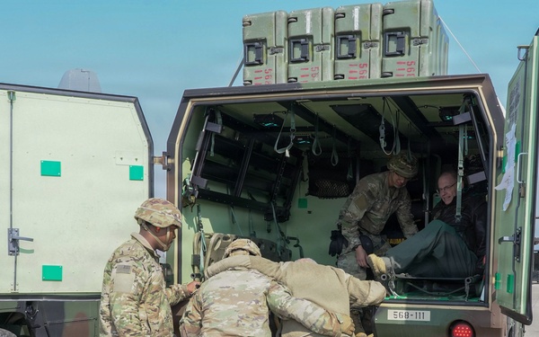 Medics load simulated patients during evacuation drill