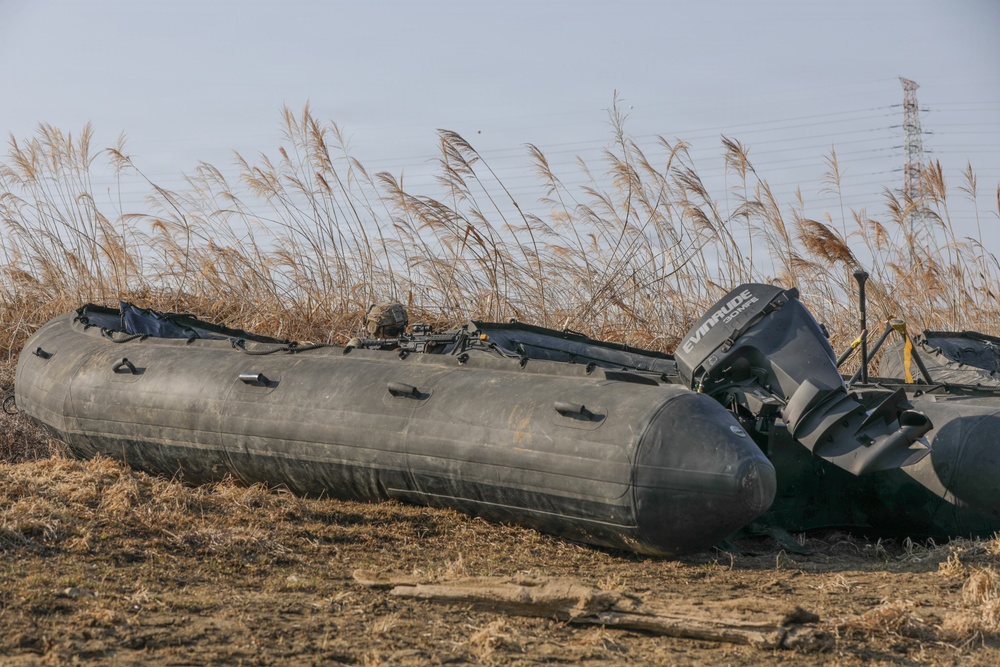 Soldiers launch Zodiac boats into river