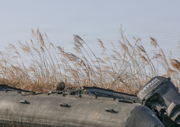 Soldiers launch Zodiac boats into river