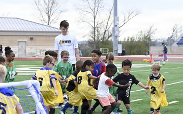 Children run, kick, dribble with All-Army soccer at youth soccer clinic