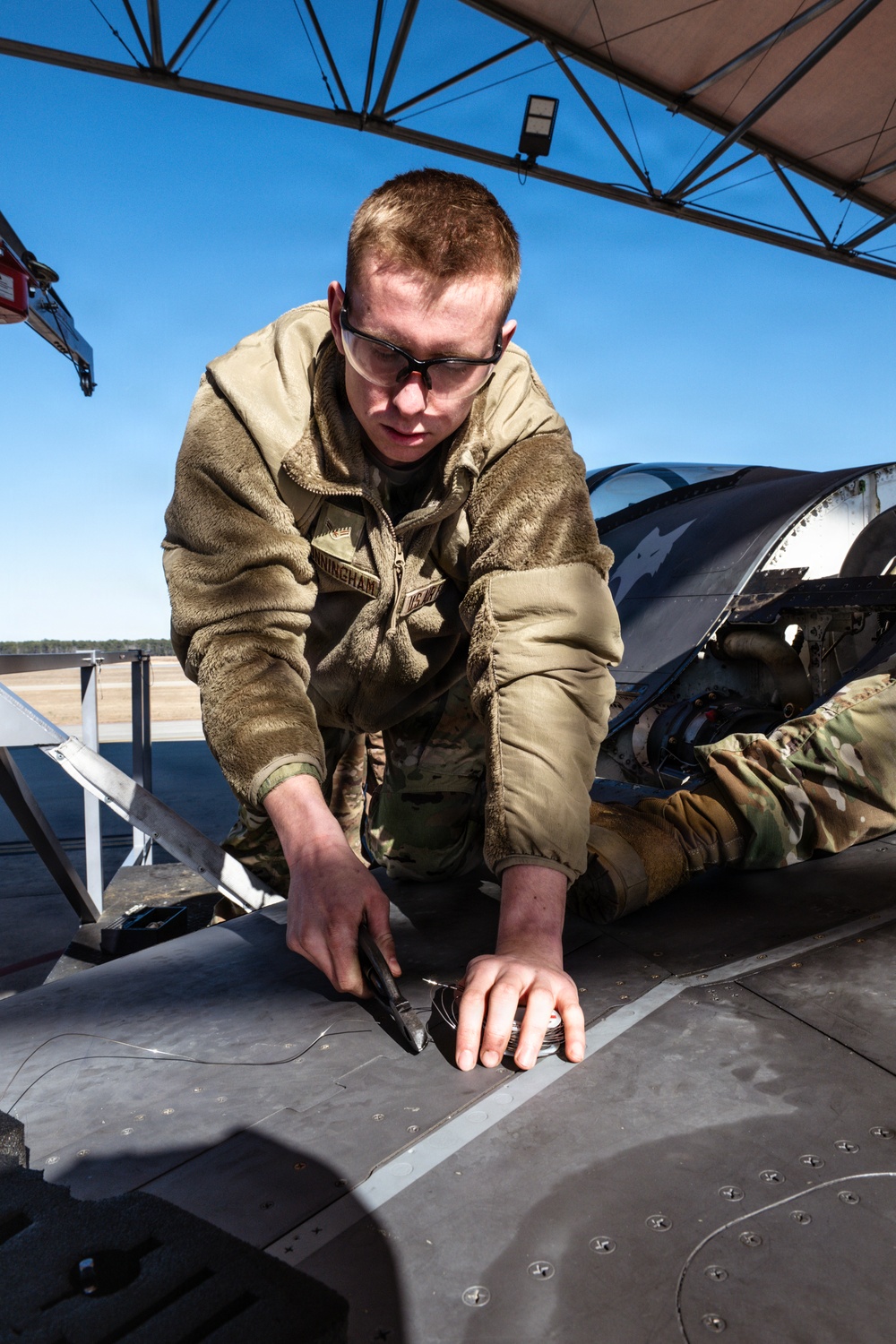 Weapons backshop inspects a gun on an F-16 Fighting Falcon