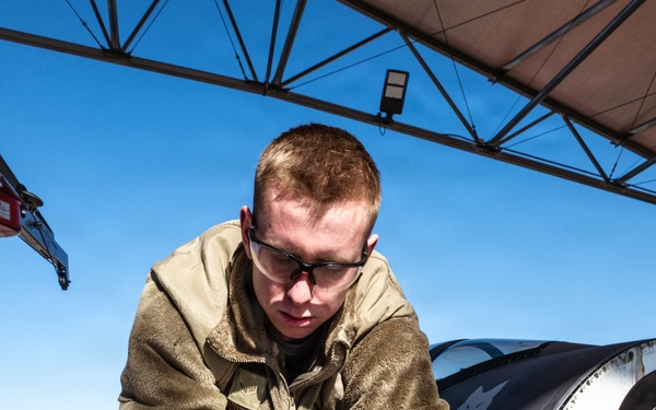 Weapons backshop inspects a gun on an F-16 Fighting Falcon
