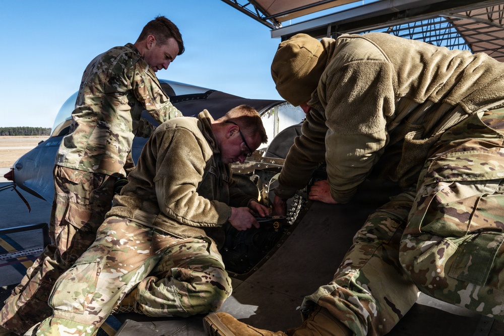 Weapons backshop inspects a gun on an F-16 Fighting Falcon