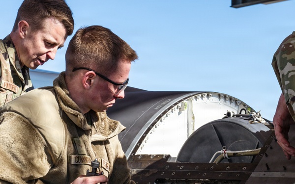 Weapons backshop inspects a gun on an F-16 Fighting Falcon