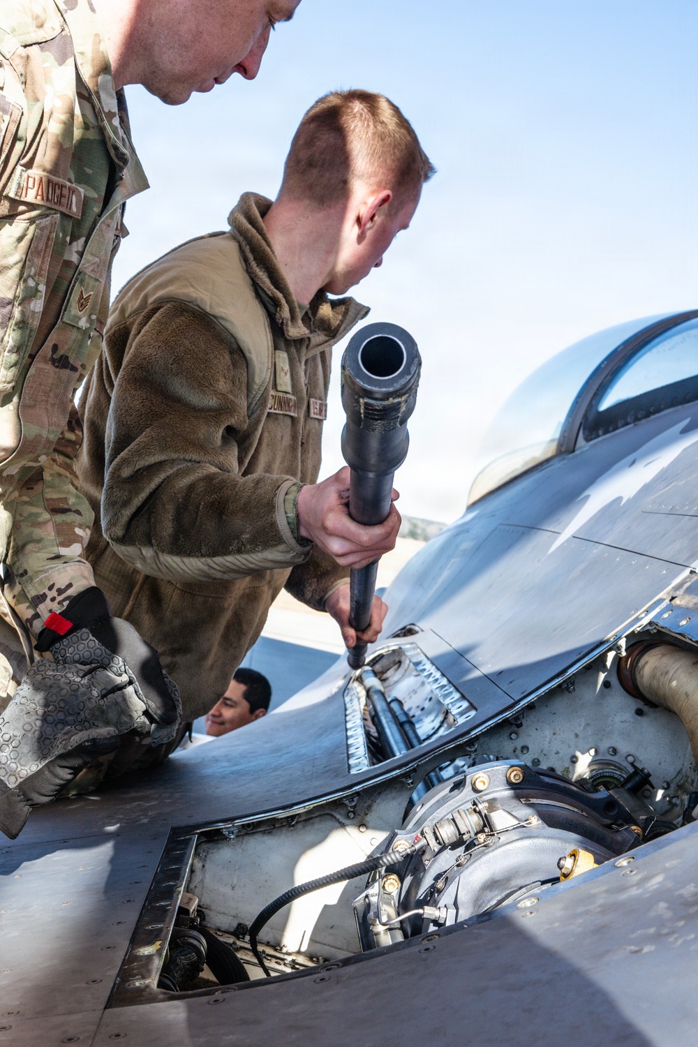 Weapons backshop inspects a gun on an F-16 Fighting Falcon