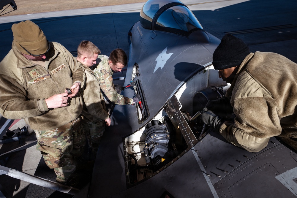 Weapons backshop inspects a gun on an F-16 Fighting Falcon