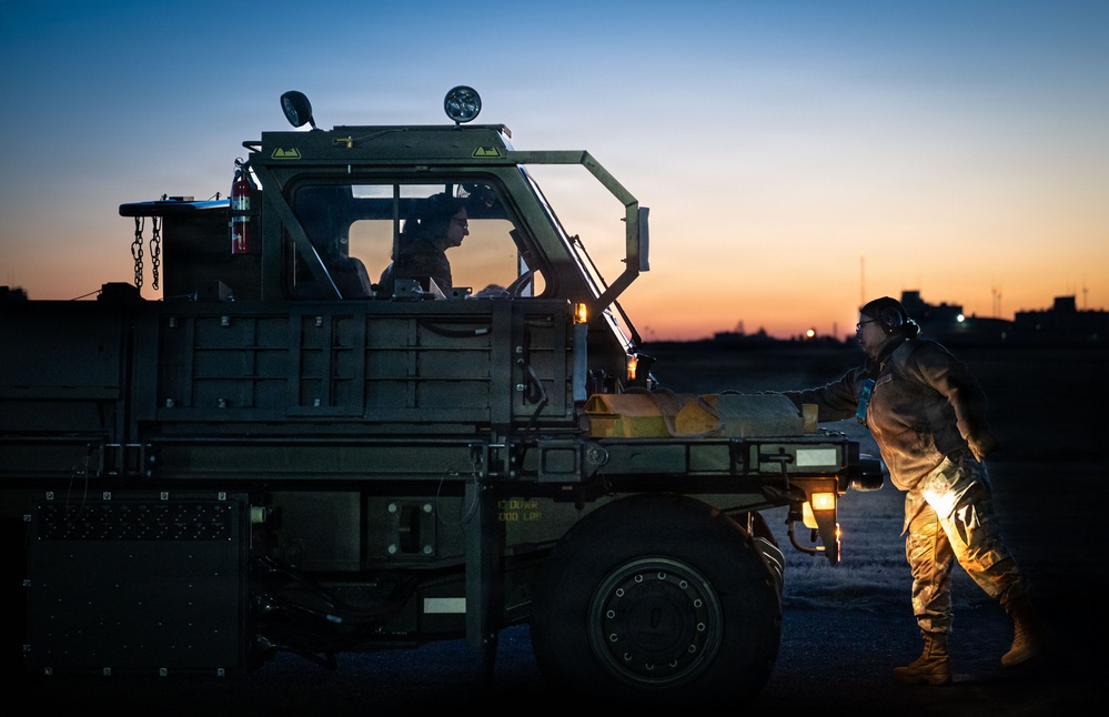 374 LRS loads heavy equipment during BM26