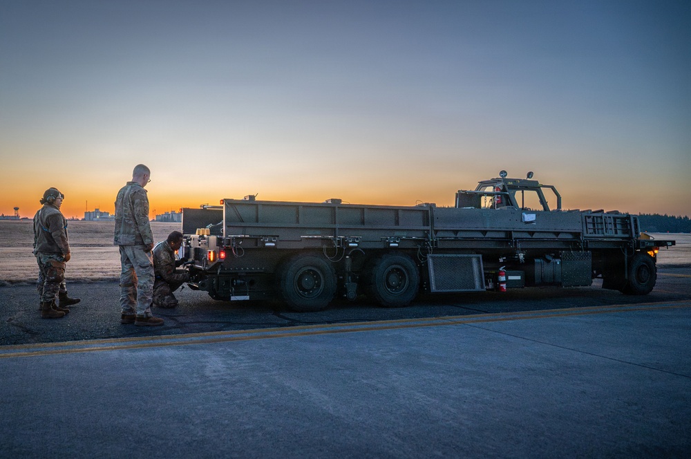 374 LRS loads heavy equipment during BM26