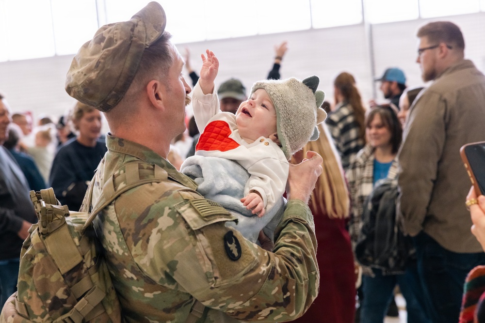 Iowa Soldier Holds Infant at Welcome Home Ceremony in Des Moines