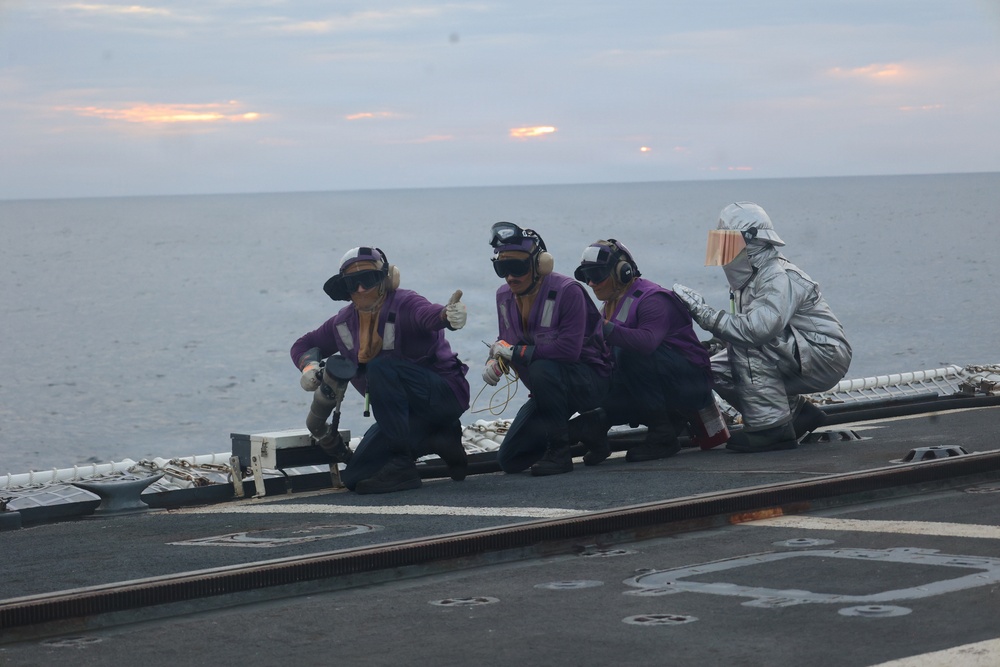 Coast Guard Cutter Forward crew members fuel embarked helicopter at sea
