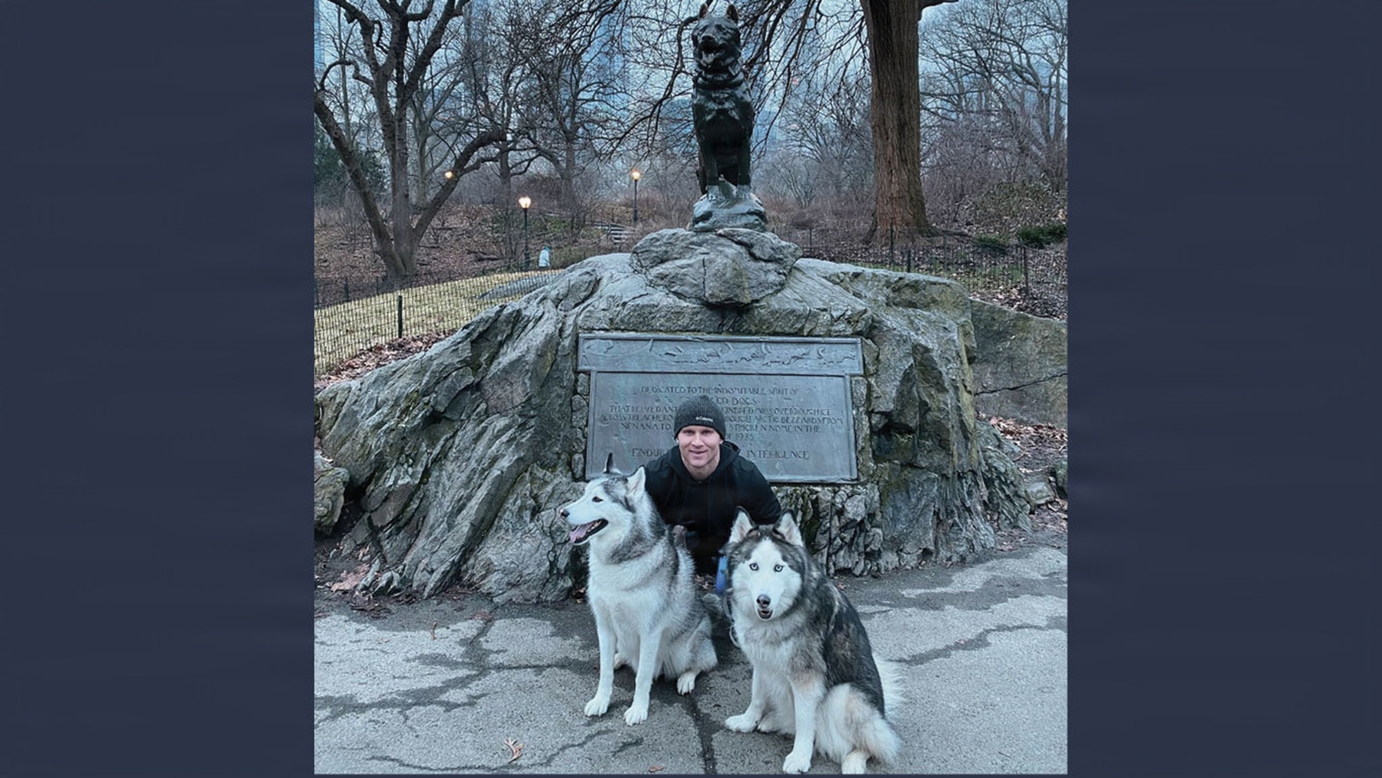 MAJ Chris Foster poses with his husky dogs Tait and Quorra.