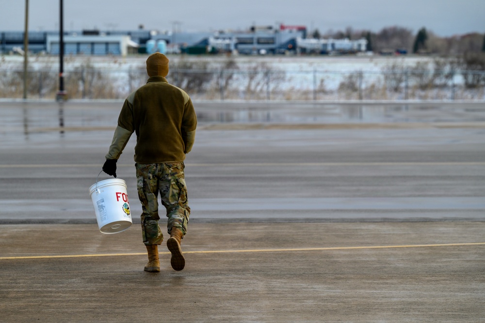 174th Attack Wing Airman conducts FOD walk in winter weather