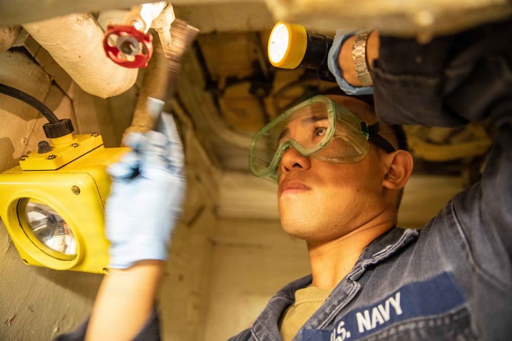 USS Mitscher (DDG 57) Sailor conducts maintenance