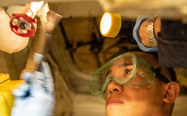 USS Mitscher (DDG 57) Sailor conducts maintenance