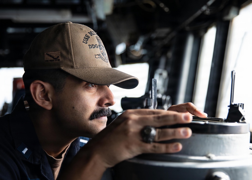 USS Mitscher (DDG 57) Sailor stands watch on ship bridge
