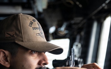 USS Mitscher (DDG 57) Sailor stands watch on ship bridge