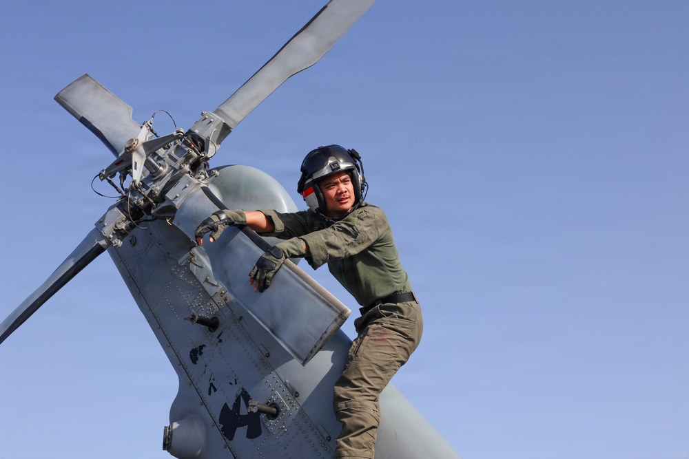 U.S. Sailors conduct preflight maintenance on an MH-60R Sea Hawk helicopter aboard USS John Finn