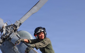 U.S. Sailors conduct preflight maintenance on an MH-60R Sea Hawk helicopter aboard USS John Finn
