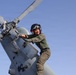 U.S. Sailors conduct preflight maintenance on an MH-60R Sea Hawk helicopter aboard USS John Finn