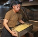 U.S. Sailors prepare food in the galley of USS John Finn