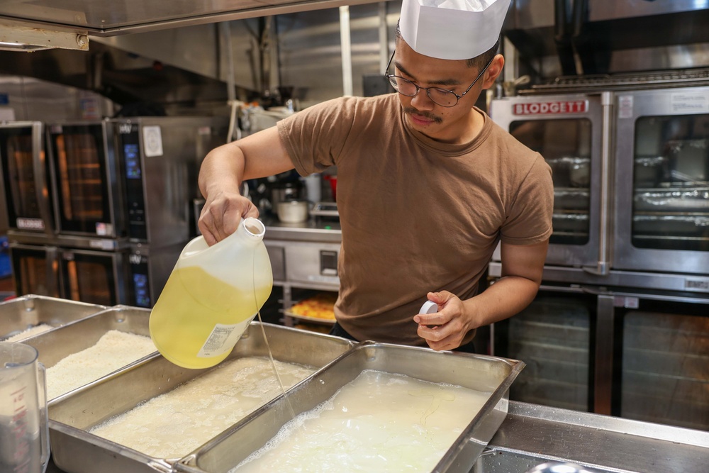 U.S. Sailors prepare food in the galley of USS John Finn