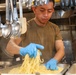 U.S. Sailors prepare food in the galley of USS John Finn