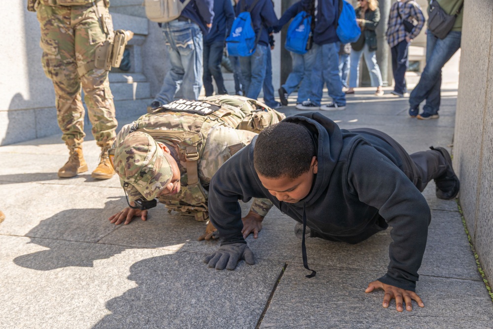 Mississippi National Guard Soldier engages in push-ups with a member of the public