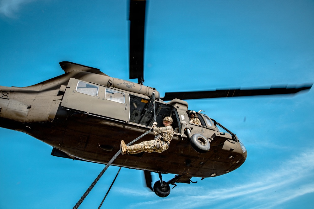 7th SFG (A) soldier fast ropes from UH-60