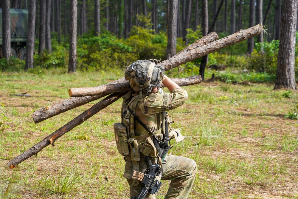 101st Soldier cuts wood to improve fighting position at JRTC