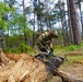 101st Soldier cuts wood to improve fighting position at JRTC