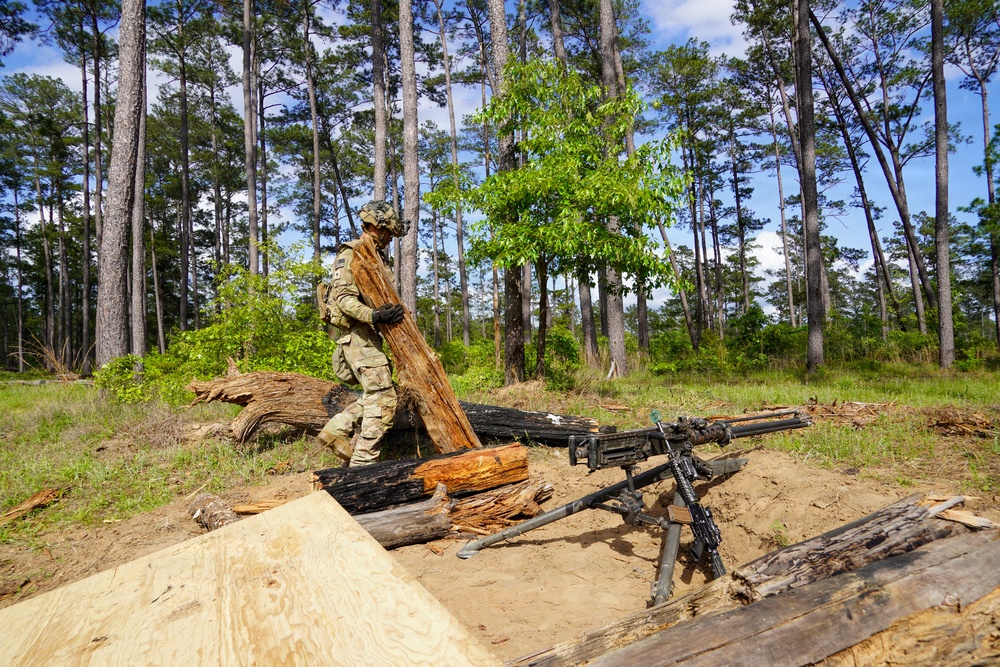 101st Soldier cuts wood to improve fighting position at JRTC