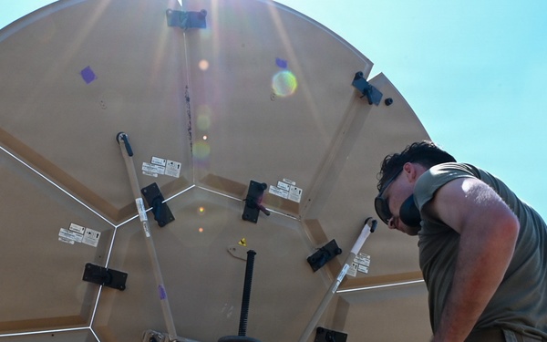 U.S. Air Force 644th Combat Communication Squadron Airmen installs a satellite communication dish