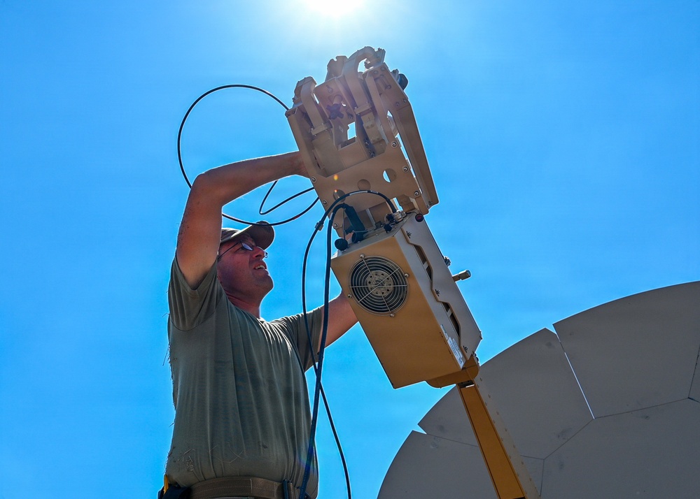 U.S. Air Force 644th Combat Communication Squadron Airmen installs a satellite communication dish