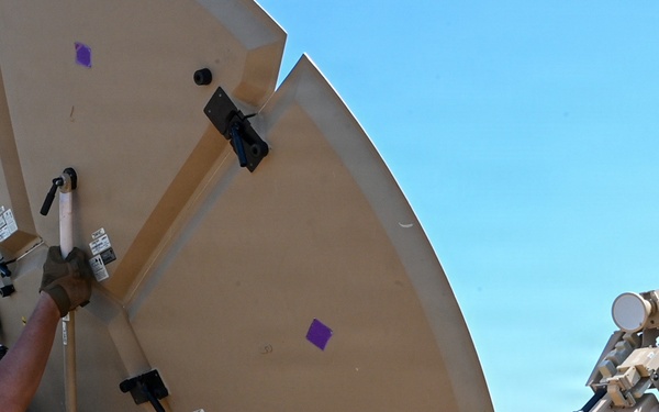 U.S. Air Force 644th Combat Communication Squadron Airmen installs a satellite communication dish