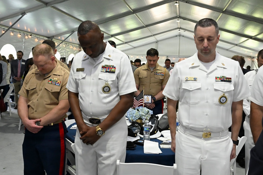 U.S. Navy Sailors and U.S. Marines bow their heads during the invocation at the Parade of Ships VIP breakfast