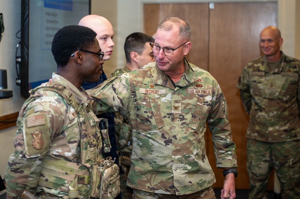 Col. Justin Secrest, 377th Air Base Wing and installation commander, coins Airman 1st Class Samuel Morrison in recognition of his swift response to a bomb threat that occurred on March 22 at the Eubank Gate at Kirtland Air Force Base