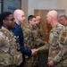 Chief Master Sgt. Andrew Rapsavage, 377th Air Base Wing command chief, presents a coin to Senior Airman Seth Fenton during a recognition ceremony at Kirtland Air Force Base