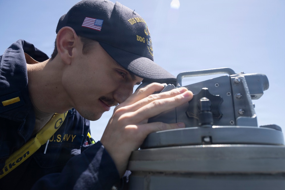 U.S Sailors stand a bridge aboard USS Delbert D. Black (DDG 119)