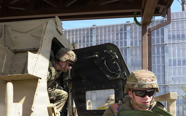 Soldiers exit the vehicle and secure the scene during training