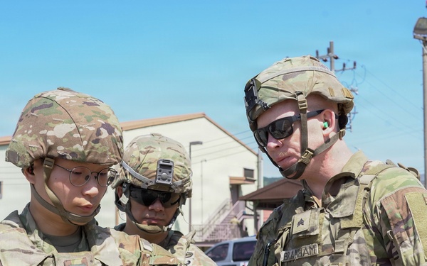 Soldier receives guidance on properly clearing weapon after live-fire iteration